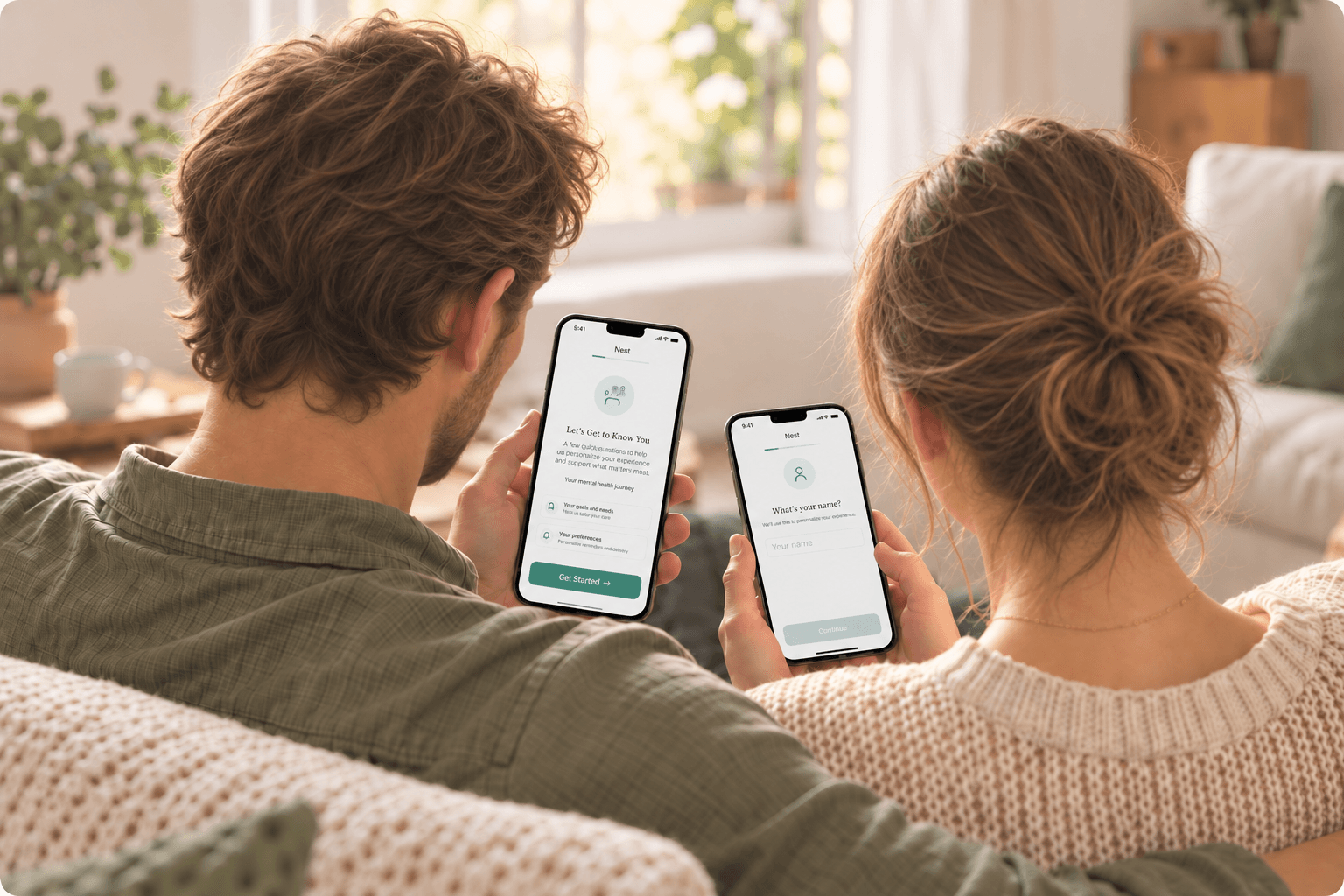 A couple sitting together at home, each looking at a phone